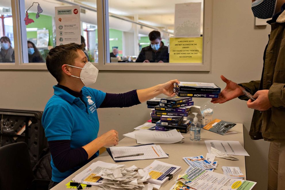 PHOTO: A healthcare worker distributes free Rapid at-home COVID-19 test kits at a vaccine clinic in Philadelphia, Penn., Dec. 20, 2021.