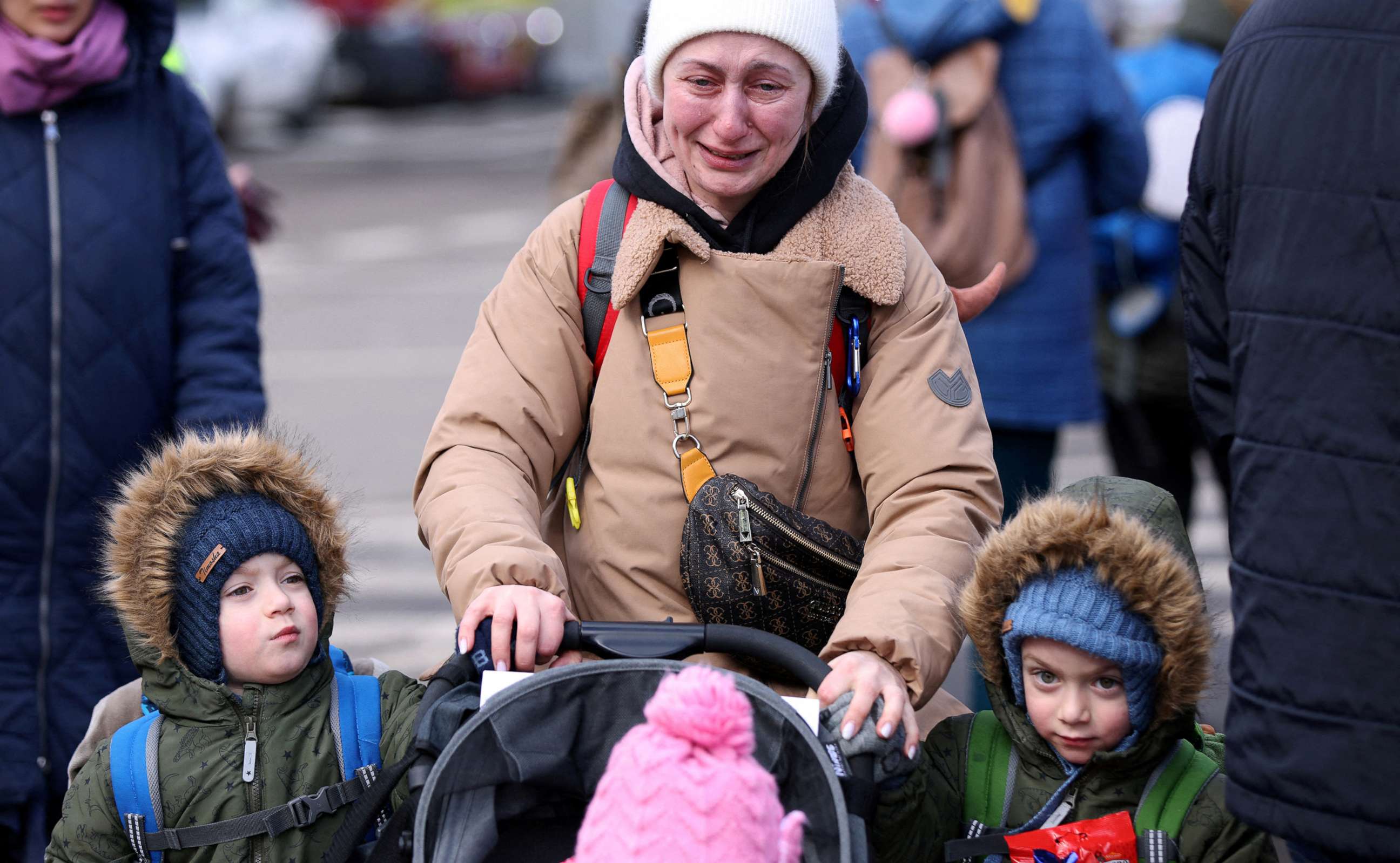 PHOTO: A woman cries as she walks with her children after fleeing from Russia's invasion of Ukraine, at the border crossing in Siret, Romania, Feb. 28, 2022.