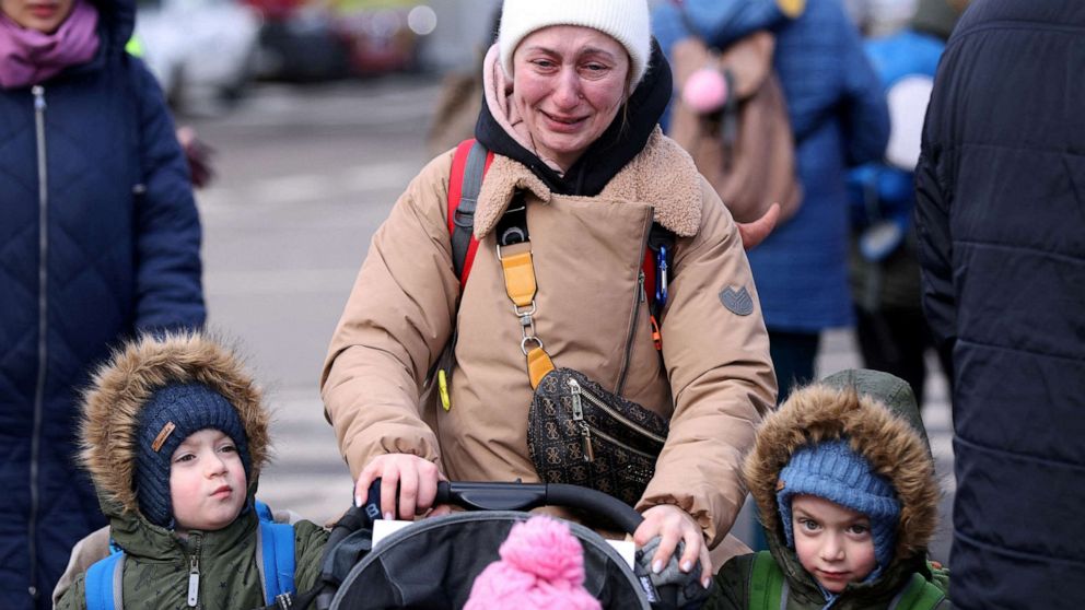 PHOTO: A woman cries as she walks with her children after fleeing from Russia's invasion of Ukraine, at the border crossing in Siret, Romania, Feb. 28, 2022.