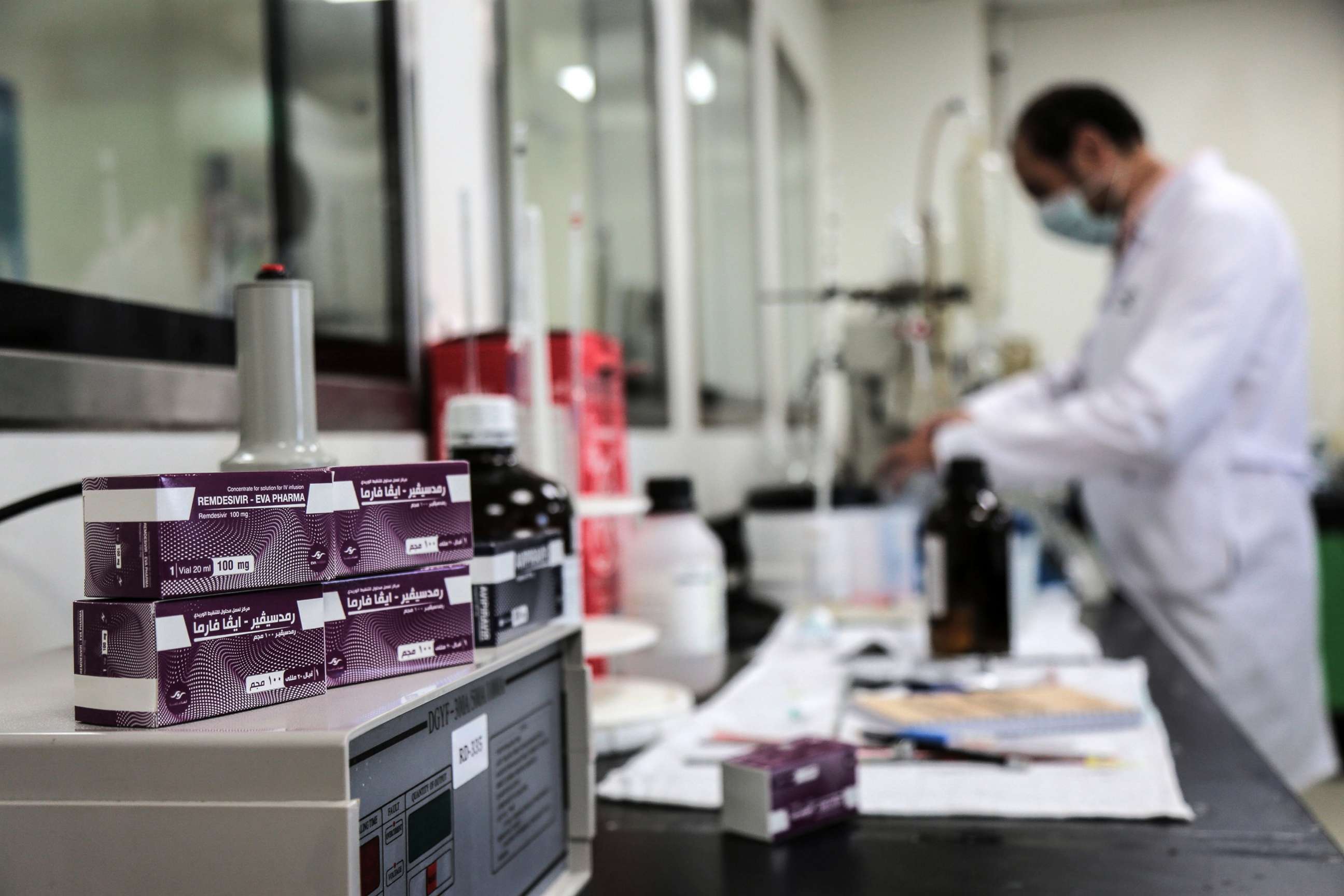PHOTO: In this June 29, 2020, file photo, packs containing vials of Remdesivir, a broad-spectrum antiviral medication approved as a specific treatment for COVID-19, lie next to an employee of Eva Pharma at the company's factory in Giza, Egypt.