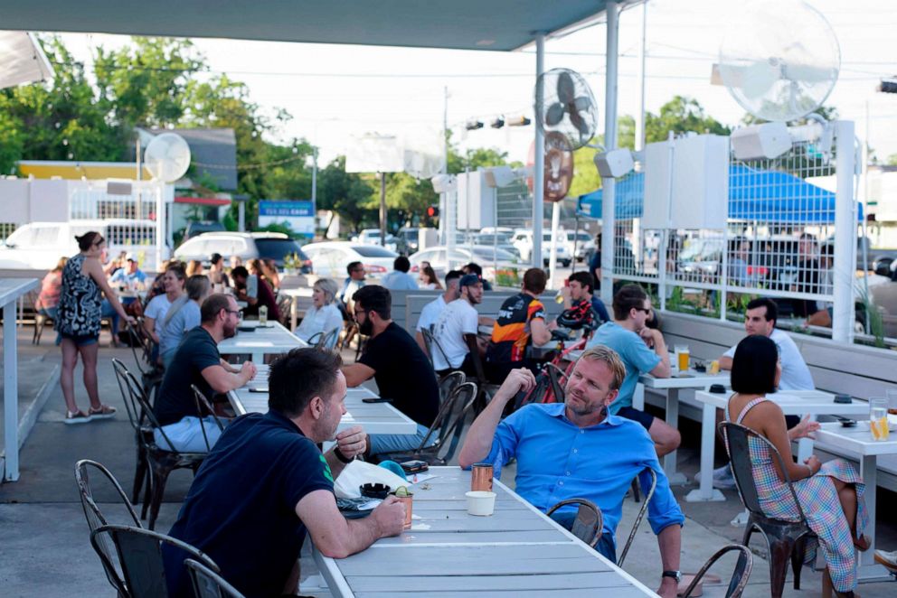 PHOTO: In this May 22, 2020, file photo, customers sit outside on the patio of a bar in Houston.