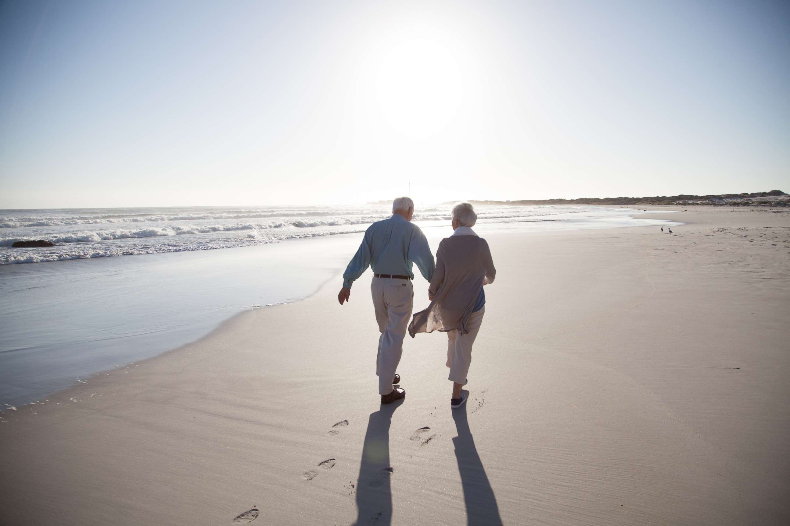 PHOTO: A senior couple enjoying time together walking on a beach at sunset in this undated stock photo.