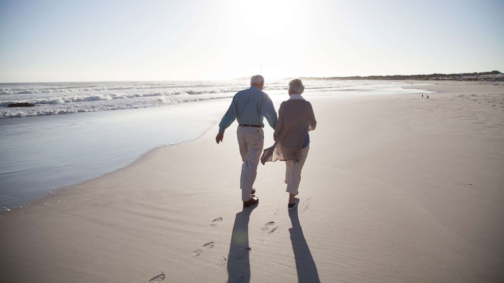 PHOTO: A senior couple enjoying time together walking on a beach at sunset in this undated stock photo.
