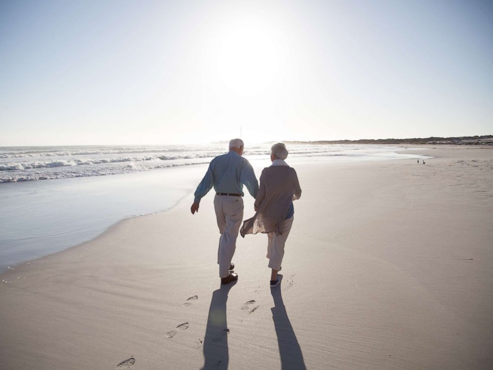 PHOTO: A senior couple enjoying time together walking on a beach at sunset in this undated stock photo.