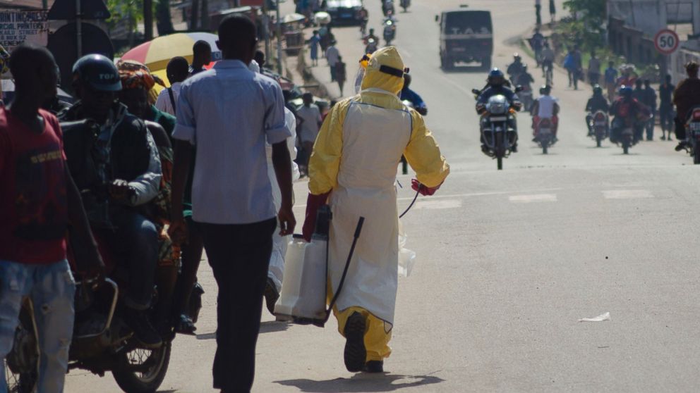 A health worker with disinfectant spray walks down a street outside the government hospital in Kenema, Sierra Leone on July 10, 2014.