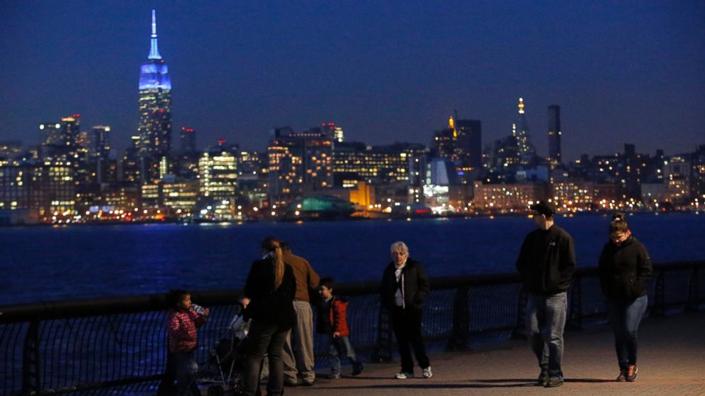 PHOTO: In this April 2, 2014 file photo, people watch the skyline of Manhattan from Hoboken, New Jersey, while the Empire State Building is seen lit up in blue to mark World Autism Day in New York.