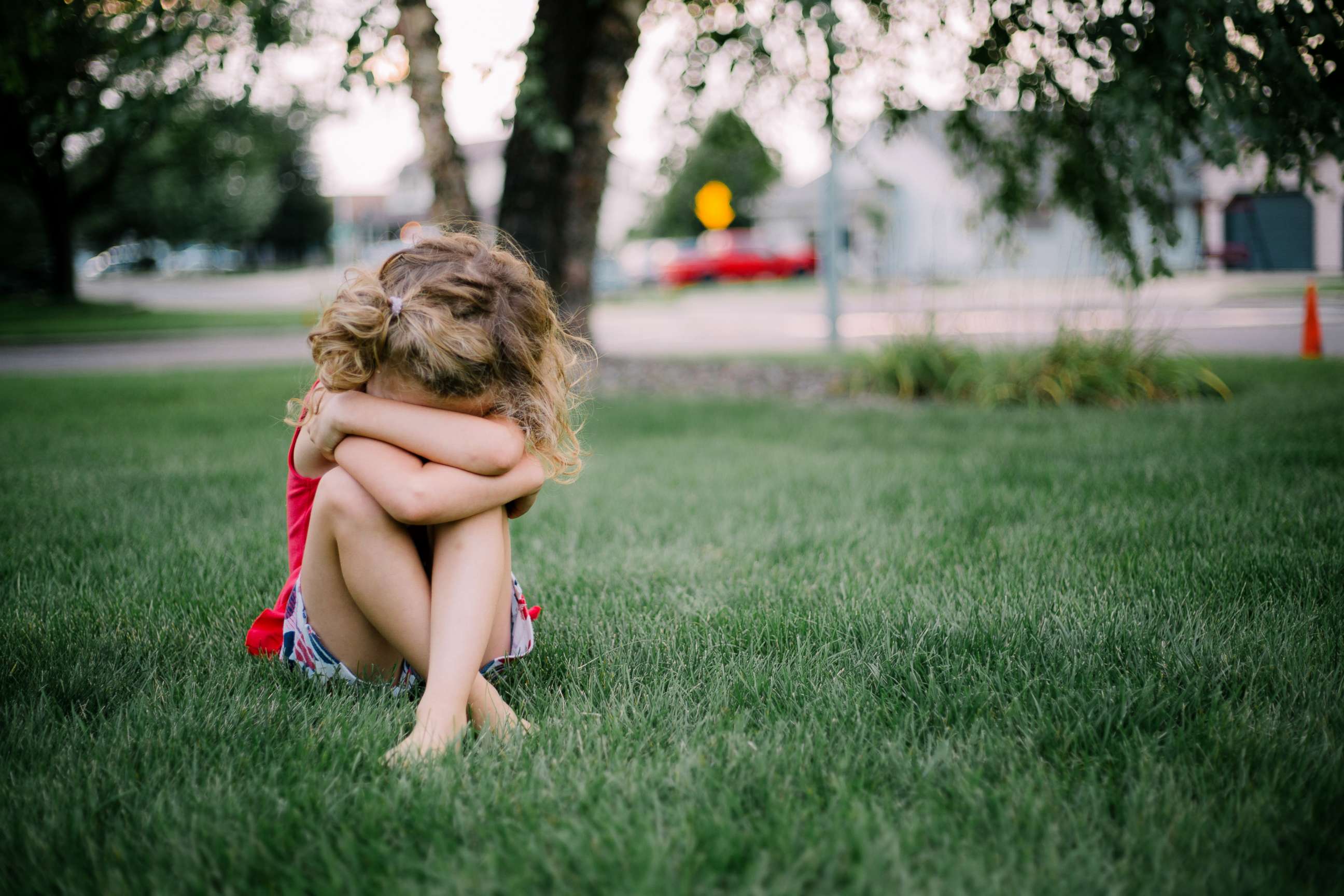 PHOTO: Little girl sits on the grass in this stock photo.