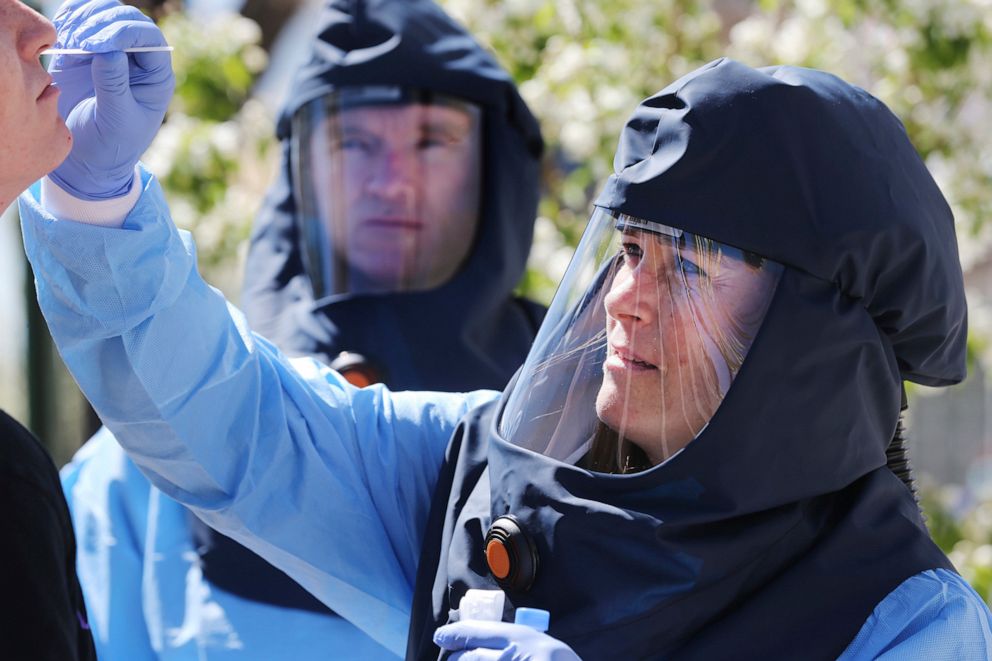 PHOTO: Public health nurse Lee Cherie Booth conducts a test for COVID-19 outside of the Salt Lake City Public Health Center, accompanied by Salt Lake County infectious disease nurse Travis Langston, April 10, 2020. 