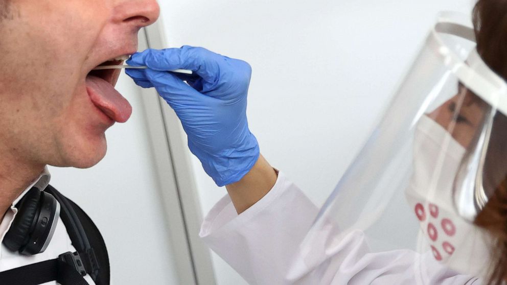 PHOTO: A saliva sample is taken at Germany's first walk-through the coronavirus disease (COVID-19) test center at the airport in Frankfurt, Germany, June 29, 2020.