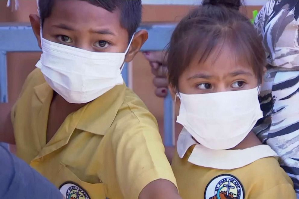 PHOTO:In this November 2019, image from video, masked children wait to get vaccinated at a health clinic in Apia, Samoa.