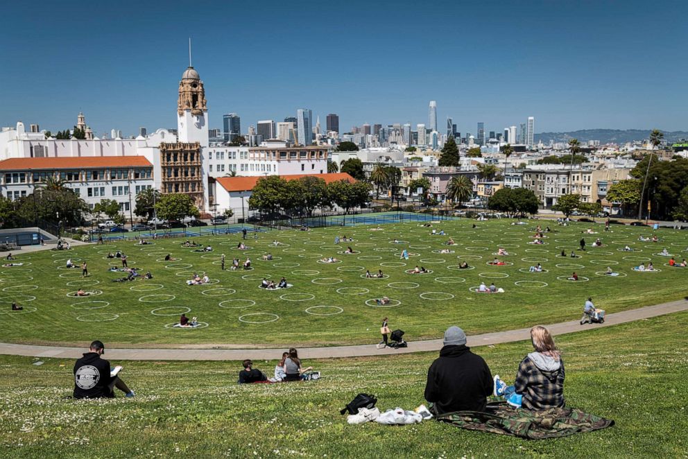 PHOTO: People sit on the grass in circles drawn to promote social distancing at Dolores Park in San Francisco, California, May 21, 2020.
