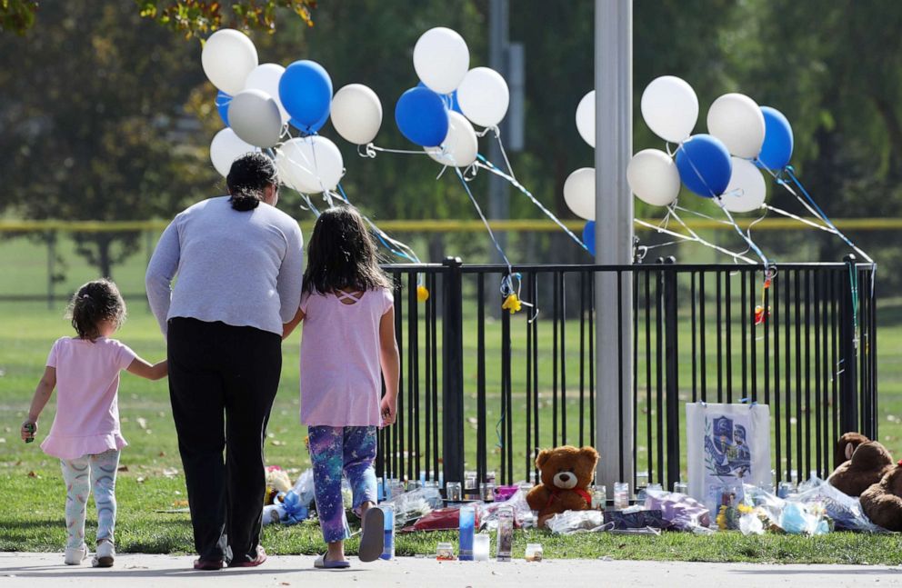 PHOTO: A woman and two girls visit a makeshift memorial in Central Park to victims of the shooting at nearby Saugus High School in Santa Clarita, Calif., Nov. 15, 2019.