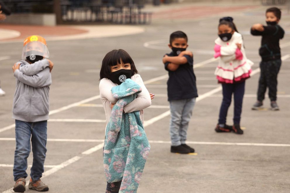 PHOTO: Kindergartners participate in a demonstration of social distance hugging as students return to class for the first time in a year at the 9th Street Elementary School in Los Angeles, on April 13, 2021.