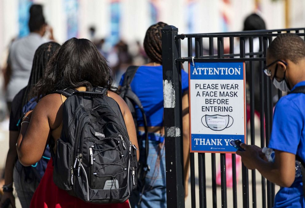 PHOTO: A sign reminds students of the mask requirement, Aug. 30, 2021, on the first day of school at Kenwood Academy in Chicago.