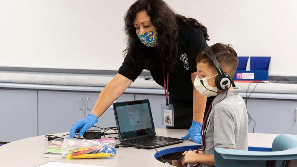 PHOTO:An instructional assistant helps a student as in-person learning resumes with restrictions in place to prevent the spread of coronavirus disease (COVID-19) at Wilson Primary School in Phoenix, Ariz., Aug. 17, 2020. 