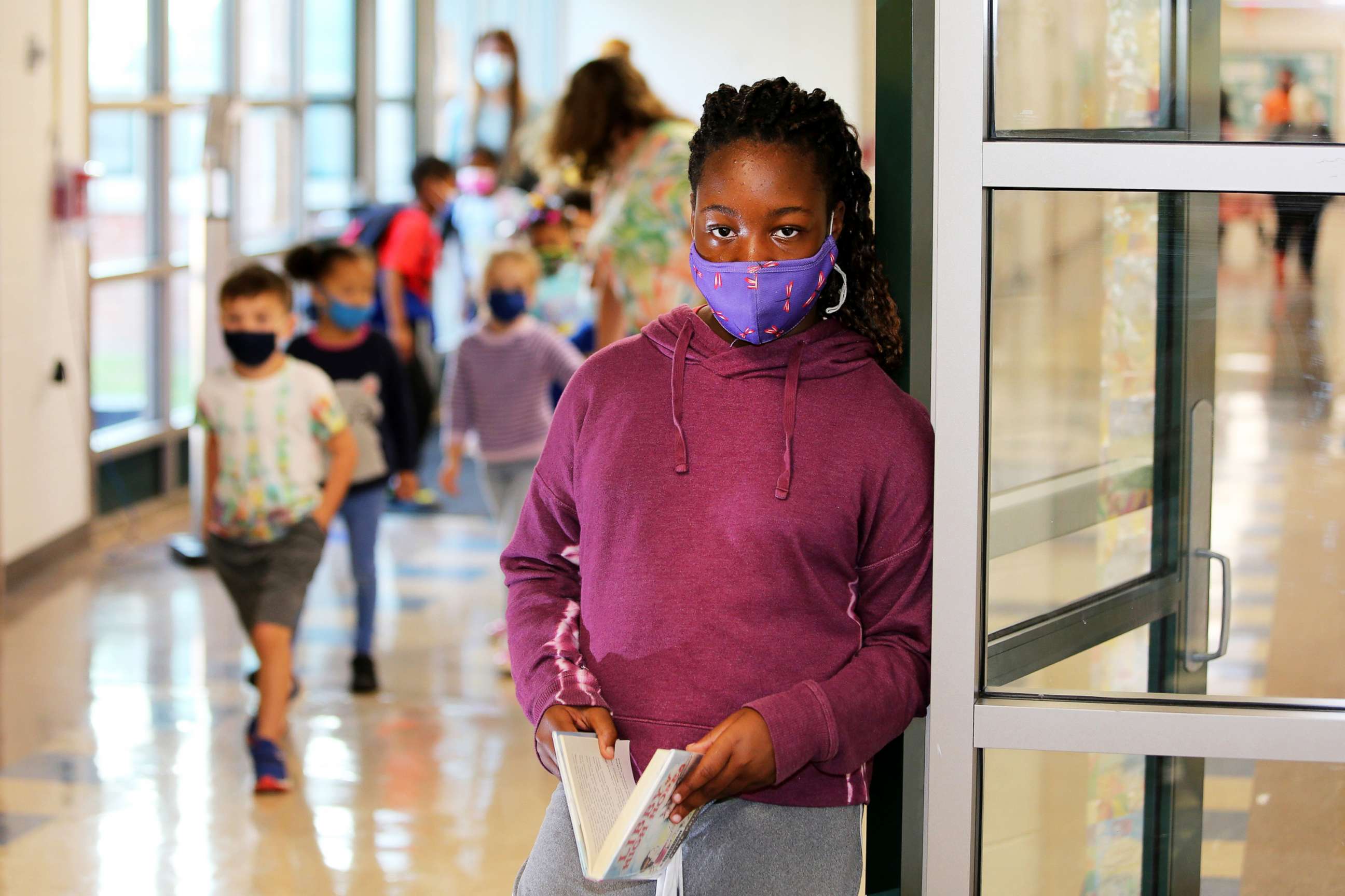 PHOTO: Fifth Grader Utibe Edet stands in a hallway as other students walk by at Bielefield Elementary School where masks are required in Middletown, Conn., Oct. 6, 2021.