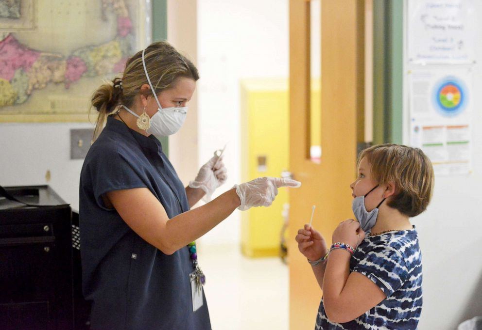 PHOTO: Harwich Elementary School nurse Holly Tavano helps her daughter, Linnea, 10, with a coronavirus test in McLean, Va., Dec. 6, 2021.