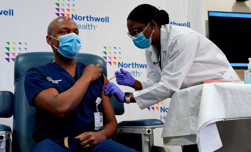 PHOTO: Dr. Yves Duroseau, chair of emergency medicine at Lenox Hill Hospital volunteers to be the second person to receive the COVID-19 vaccination administered by Michelle Chester, DNP, at Long Island Jewish Medical Center in New York, Dec. 14, 2020.