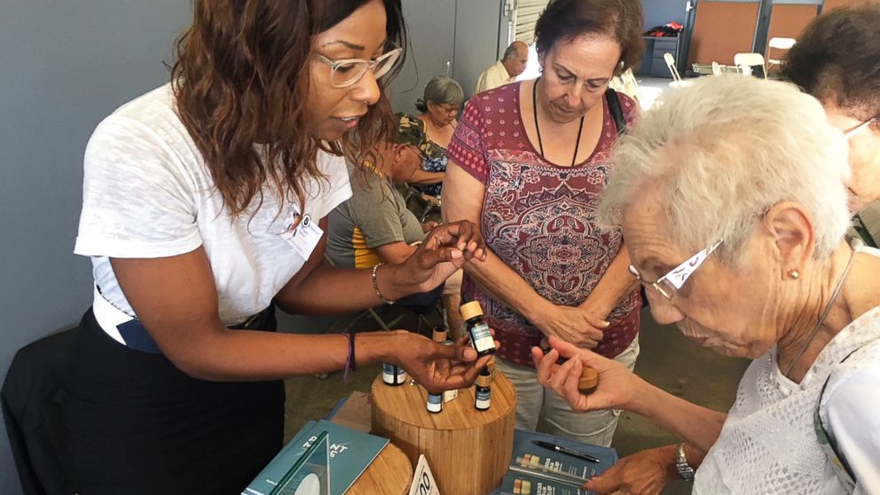 Megan Baker of Papa and Barkley Co., a cannabis company based in Eureka, Calif., shows Shirley Avedon different products intended to help with pain relief. 