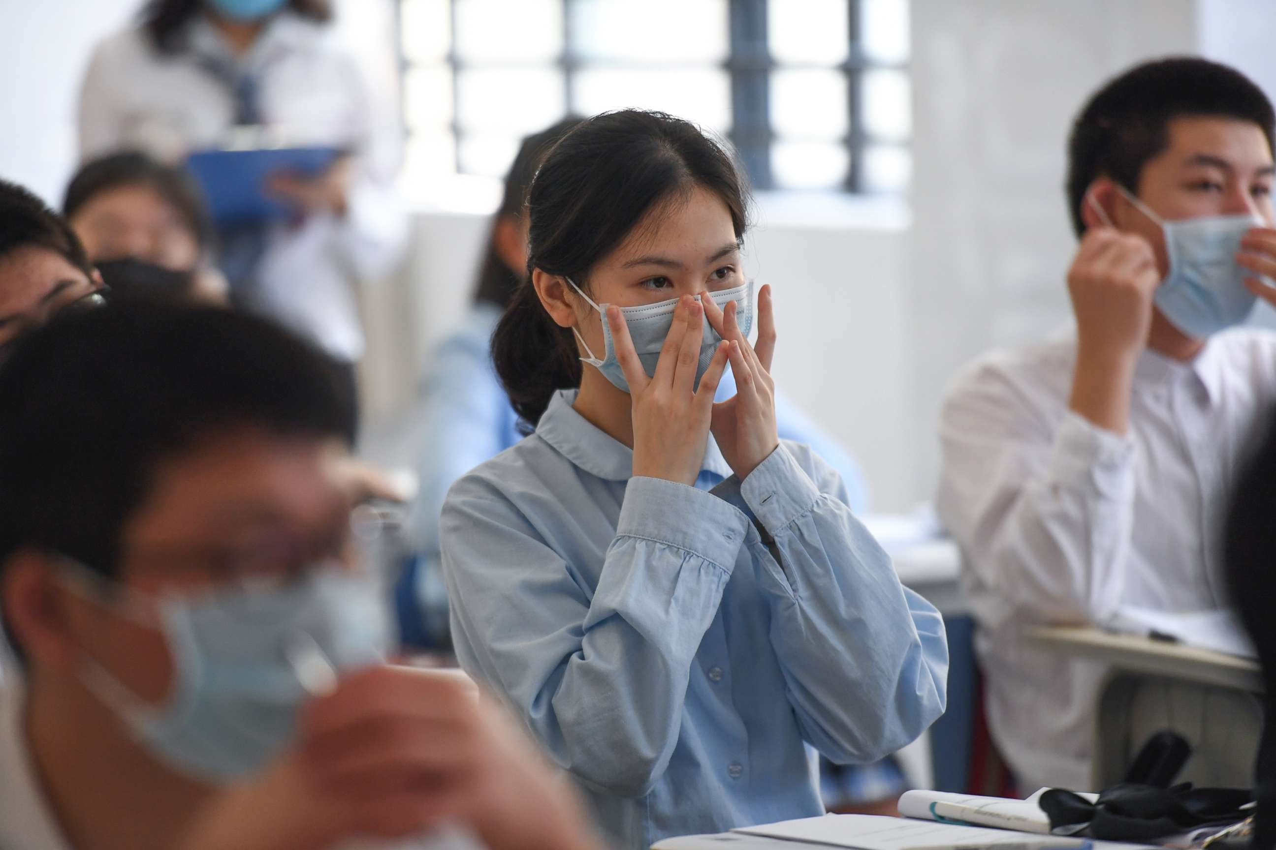 PHOTO: Ninth-grade students learn how to properly wear a face mask at Shenzhen Foreign Languages School in Shenzhen, China, April 27, 2020.