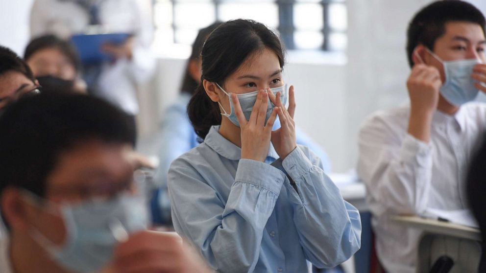 PHOTO: Ninth-grade students learn how to properly wear a face mask at Shenzhen Foreign Languages School in Shenzhen, China, April 27, 2020.