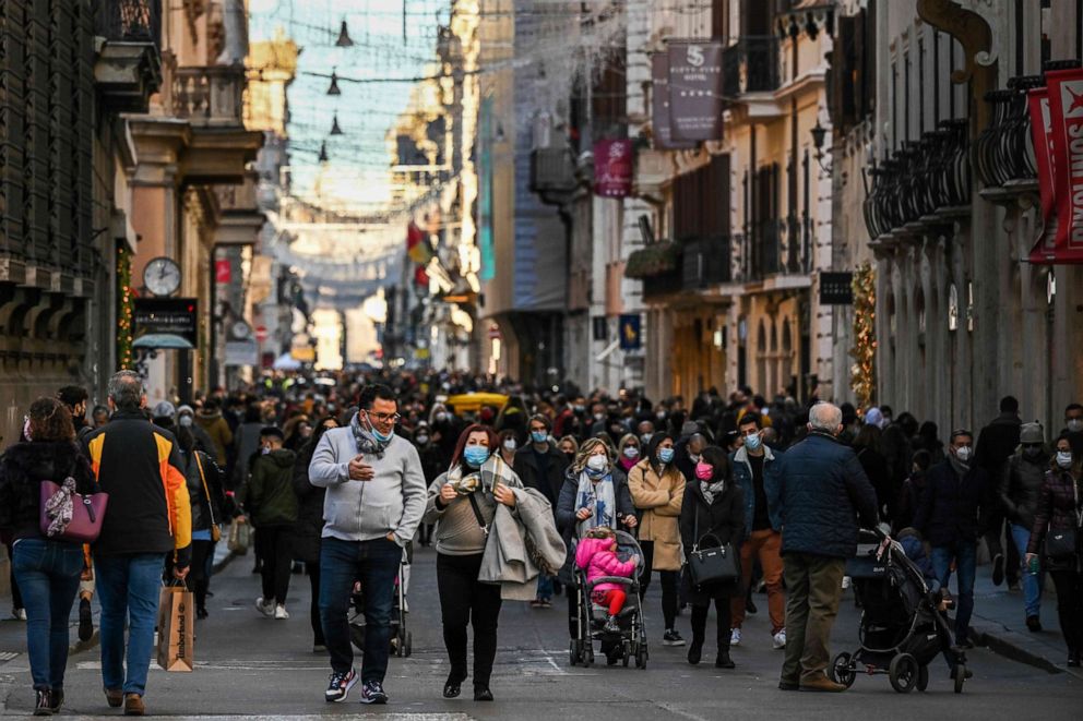 PHOTO: People wearing a face masks do their Christmas shopping, Dec. 13, 2020, in Rome, Italy, during the COVID-19 pandemic.