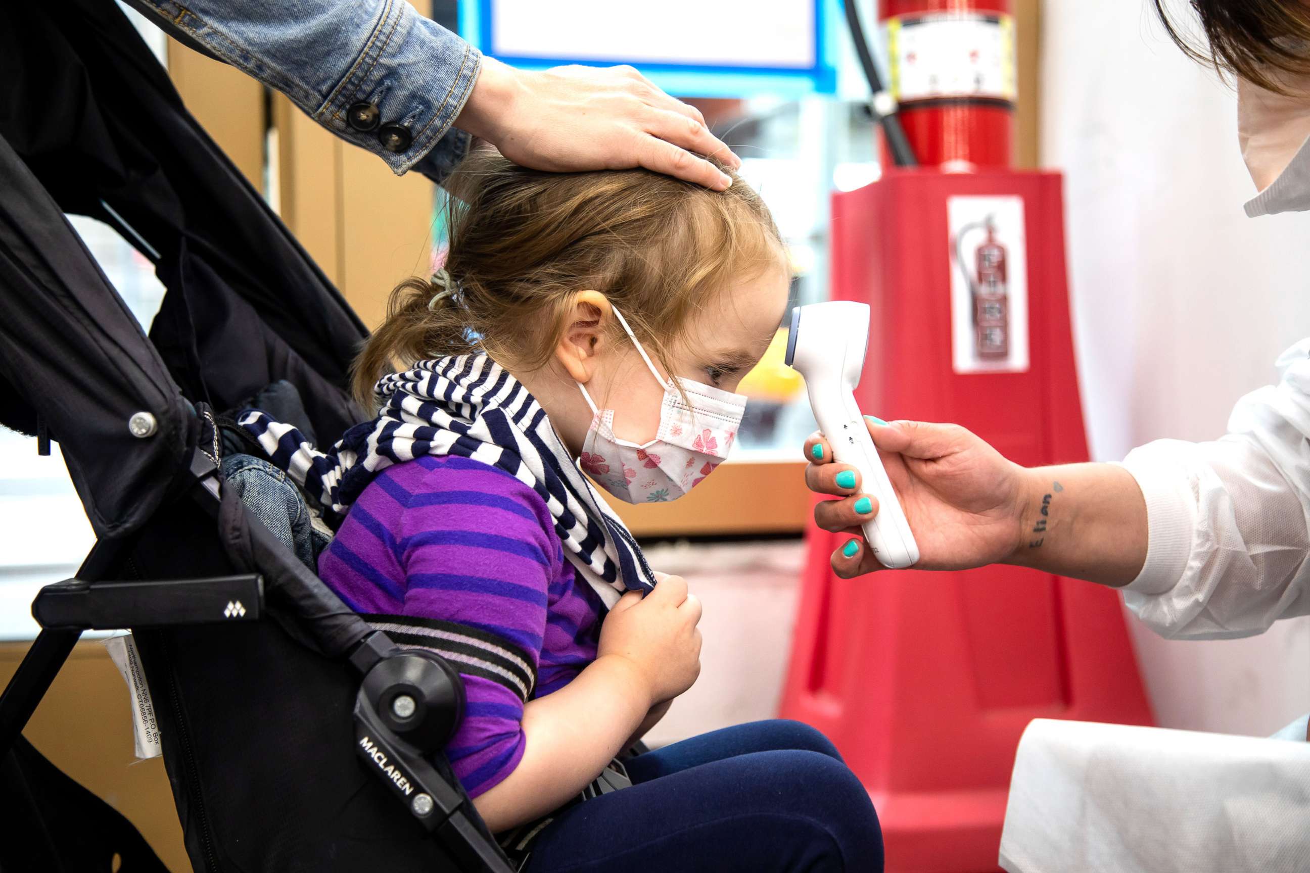 PHOTO: A child has her temperature measured at a vaccination site in New York City, on June 22, 2022. 