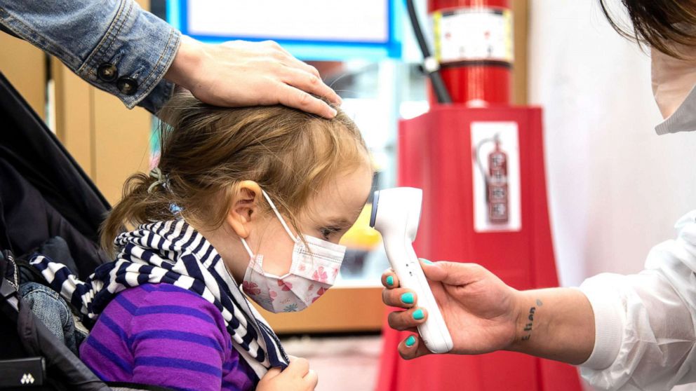 PHOTO: A child has her temperature measured at a vaccination site in New York City, on June 22, 2022. 