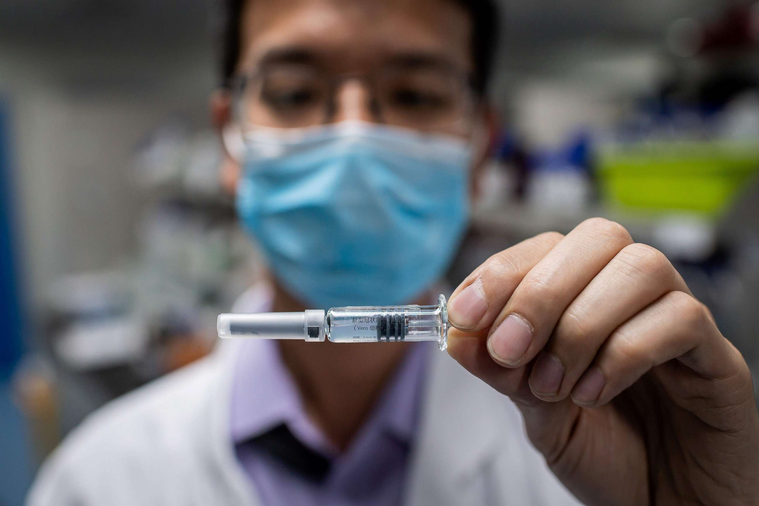 PHOTO: An engineer displays an experimental vaccine for the COVID-19 coronavirus that was tested at the Quality Control Laboratory at the Sinovac Biotech facilities in Beijing, April 29, 2020.