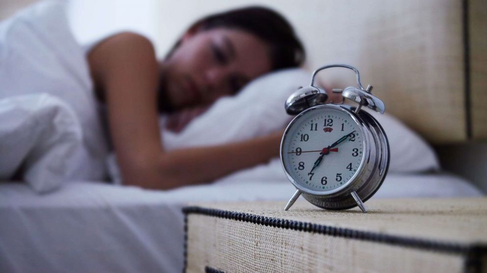 PHOTO: A young woman sleeps with an alarm clock next to her bed in this undated stock photo.