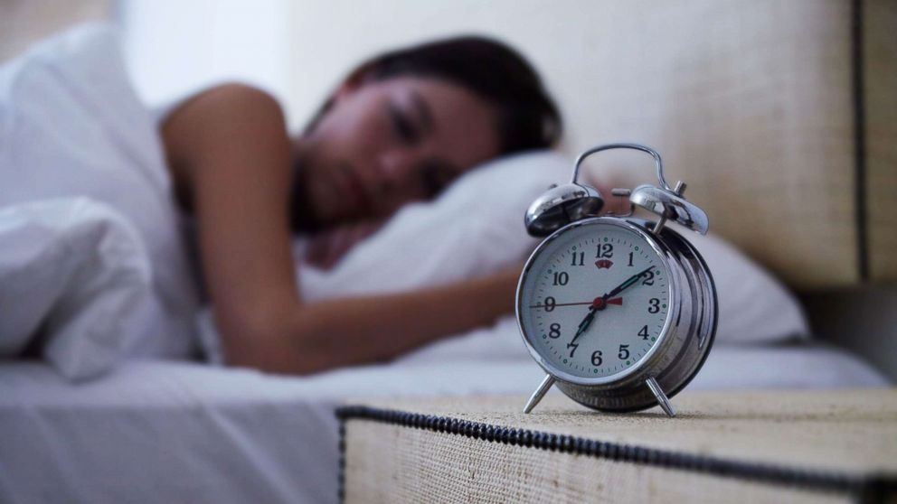 PHOTO: A young woman sleeps with an alarm clock next to her bed in this undated stock photo.