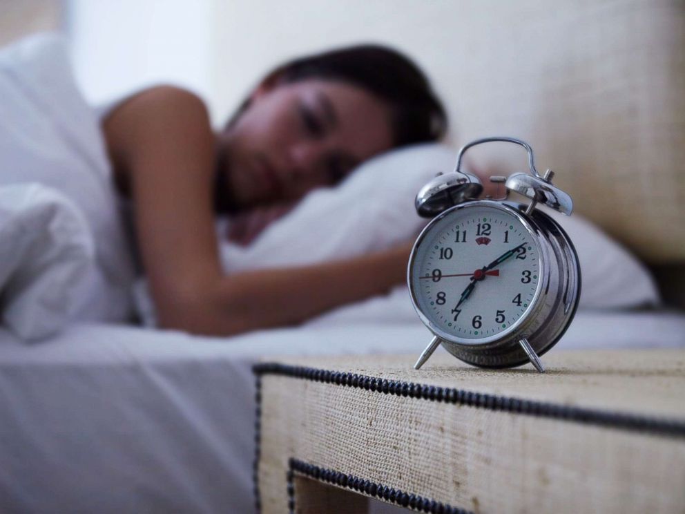 PHOTO: A young woman sleeps with an alarm clock next to her bed in this undated stock photo.