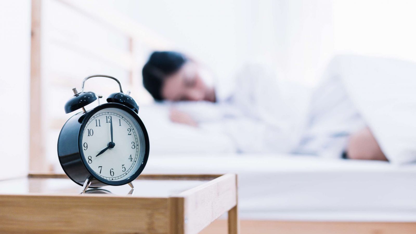 PHOTO: A woman sleeps with an alarm clock nearby.