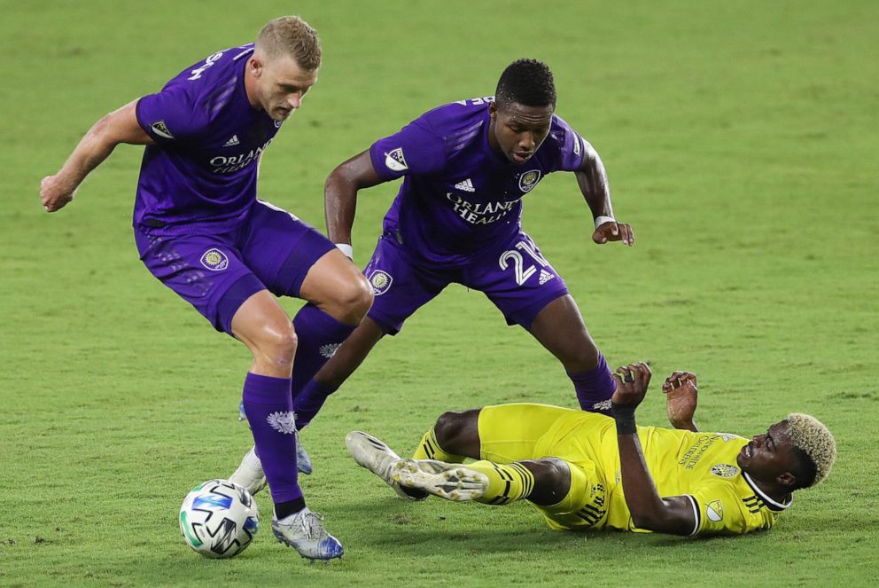 PHOTO: The Columbus Crew's Gyasi Zardes, bottom, falls under Orlando City's Robin Jansson, left, and Andres Perea at Exploria Stadium in Orlando, Fla., Nov. 4, 2020.