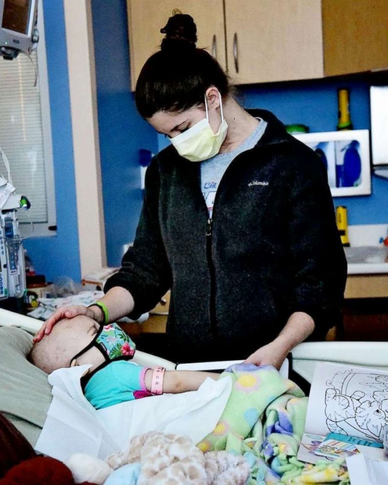 Shelby Skiles comforts her 2-year-old daughter Sophie as she undergoes treatment for T-cell lymphoma.