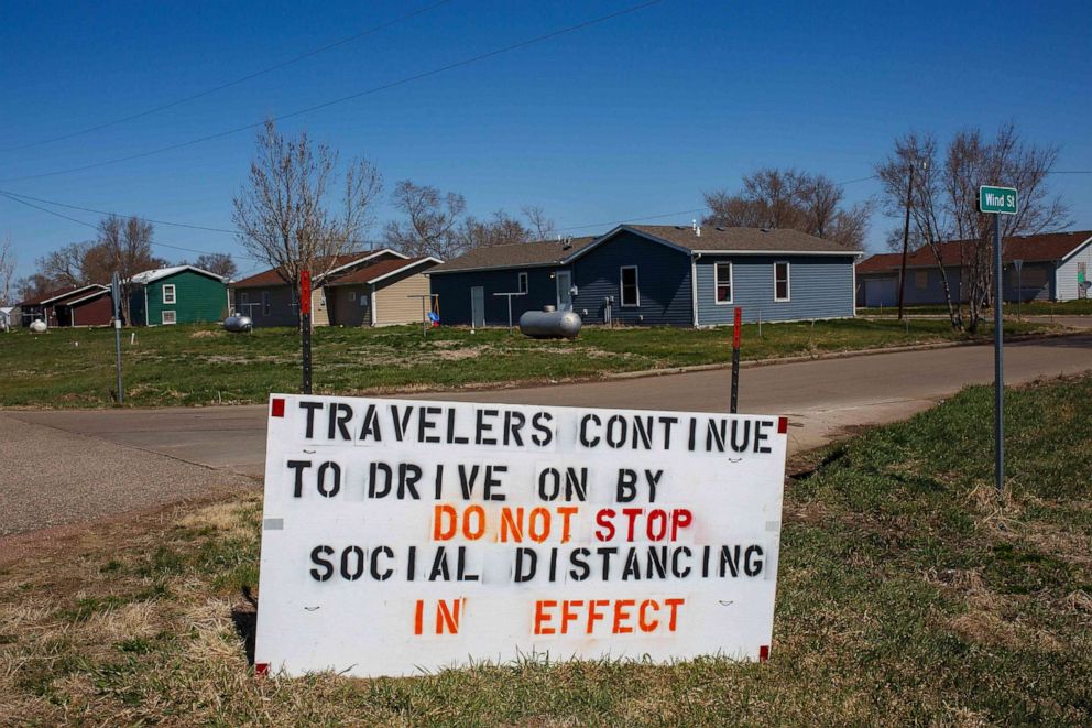 PHOTO: A sign asks travelers not to stop as social distancing is in effect in a town near in Lower Brule, S.D., on April 22, 2020.