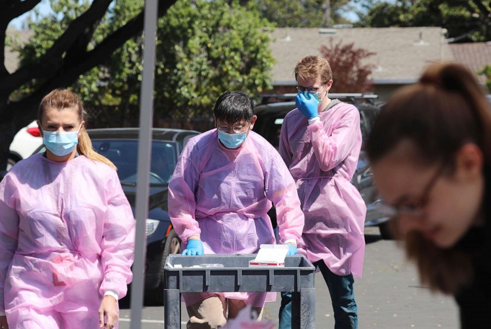 PHOTO: A staff member at the Stanford Radiology department and Stanford medical student work with other students and volunteers to prepare to take blood samples during a coronavirus antibody study in Mountain View, Calif., on Friday, April 3, 2020.