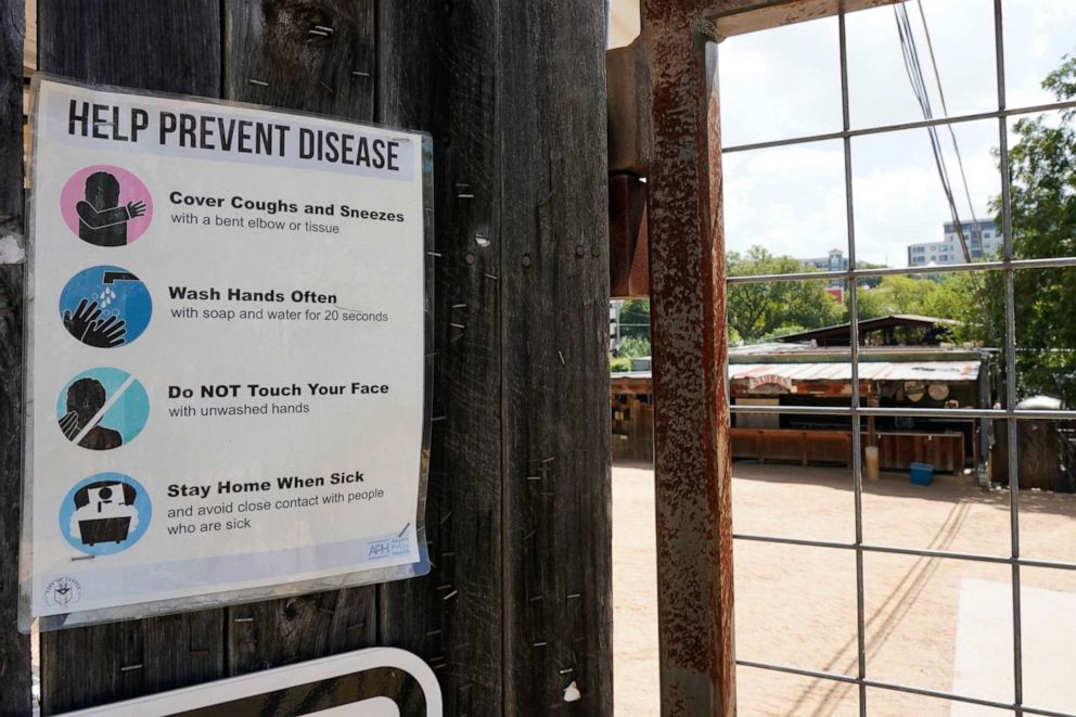 PHOTO: A sign informing customers how to prevent disease is displayed near the entrance to Stubb's BBQ Amphitheater in Austin, Texas, Saturday, Aug. 21, 2021.