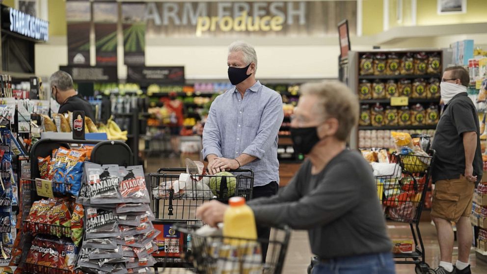 PHOTO: Shoppers wearing protective masks stand in the check-out line at an Albertsons Cos. grocery store in San Diego, California, June 22, 2020.