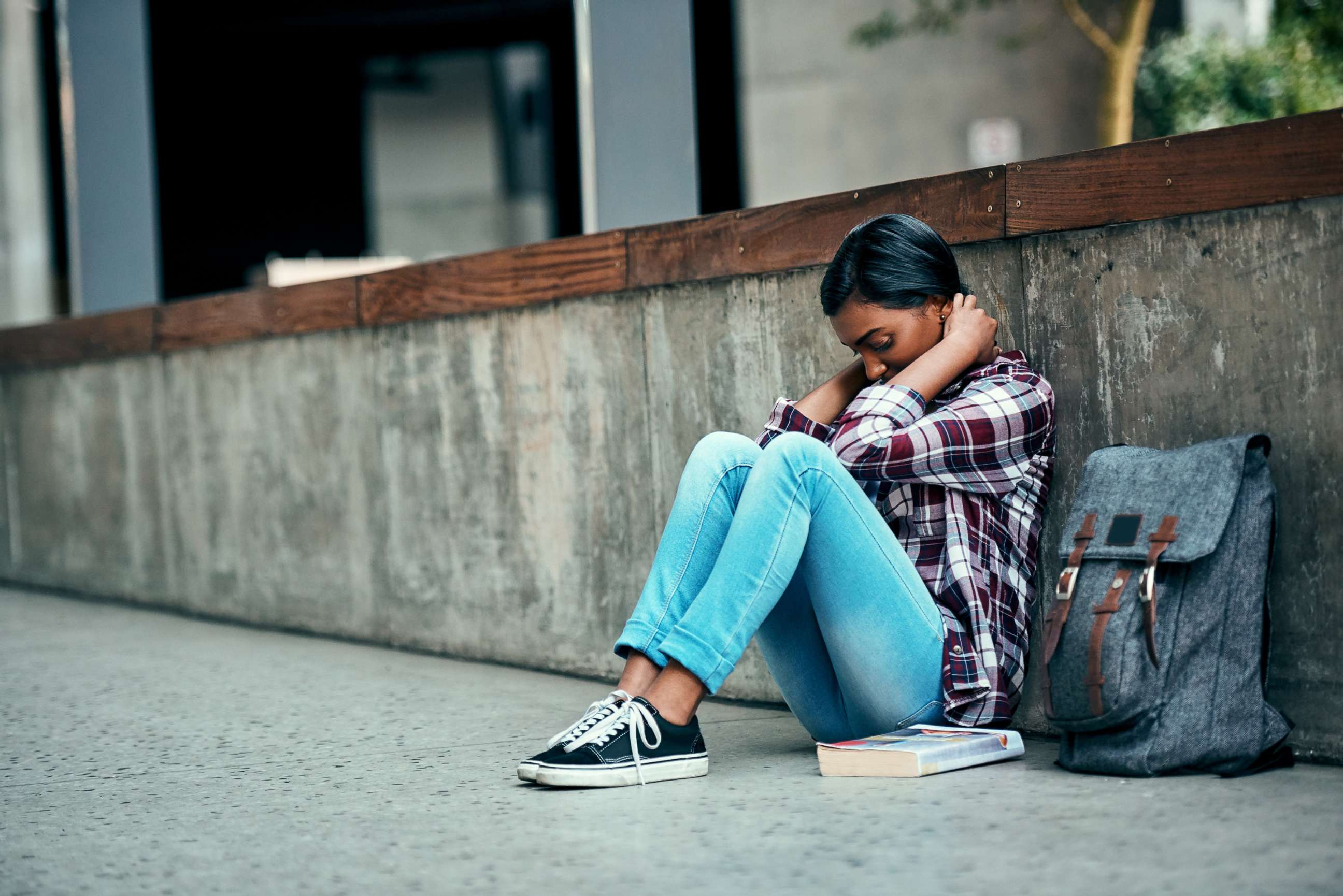 PHOTO: An undated stock photo depicts a young female college student sitting alone on campus.