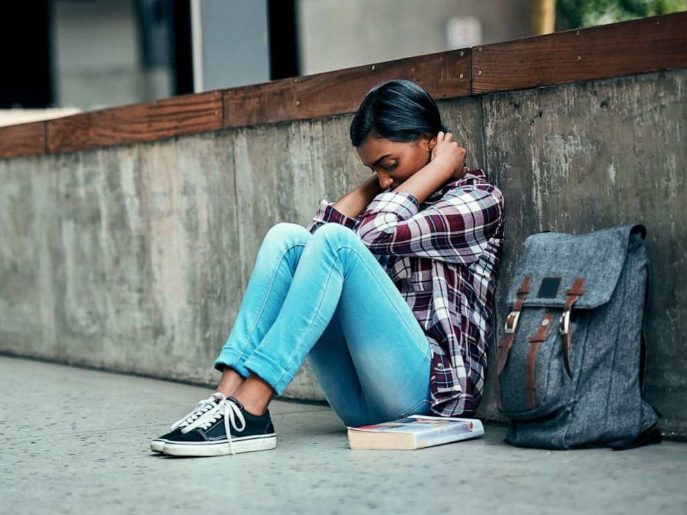 PHOTO: An undated stock photo depicts a young female college student sitting alone on campus.