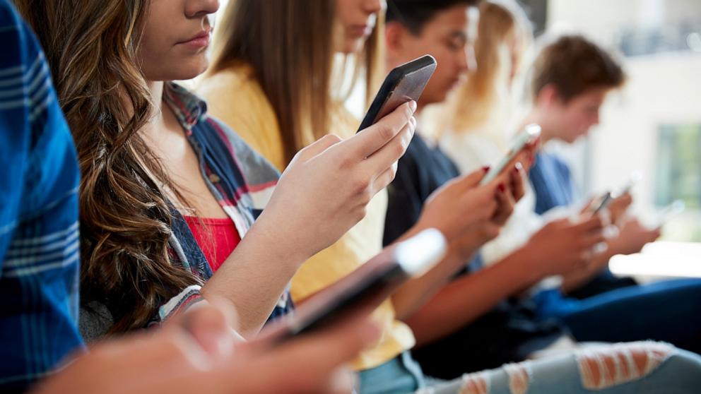 PHOTO: High school students use their mobile phones.