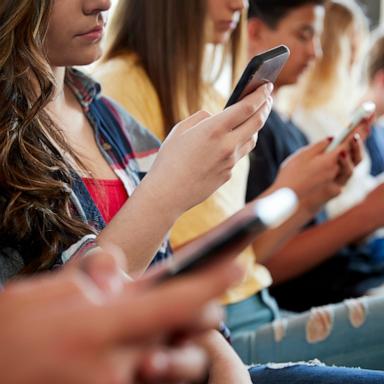 PHOTO: High school students use their mobile phones.