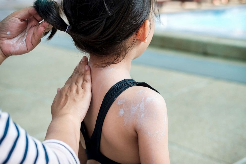 PHOTO: A woman applies sunscreen on a child in this stock photo.