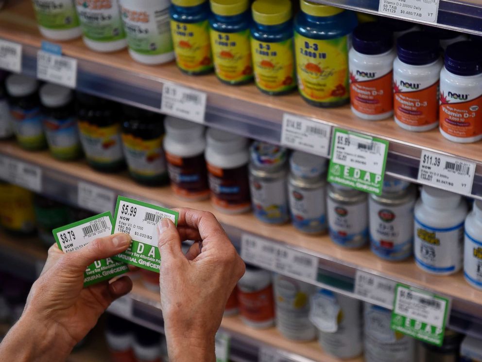 PHOTO: A store worker affixes price tags to vitamins at a grocery storey on July 26, 2017, in Denver.