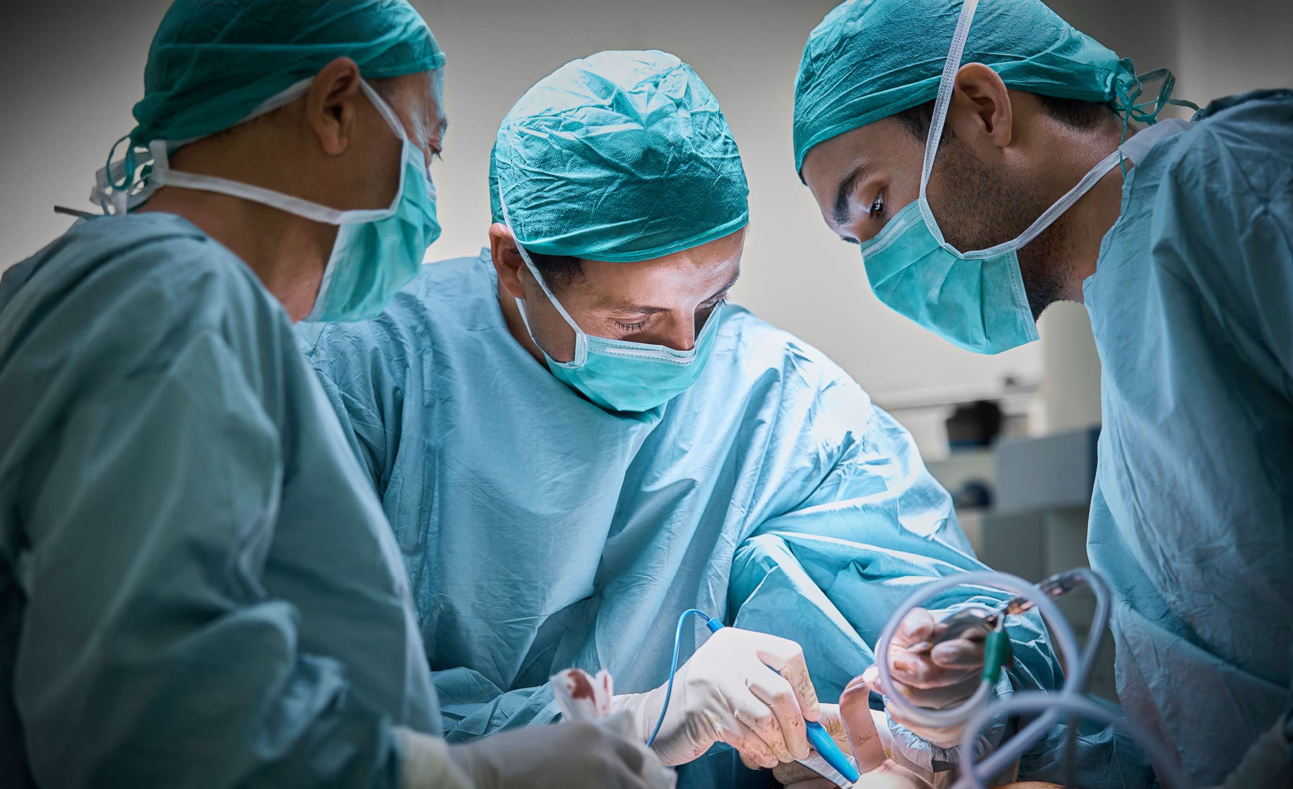 PHOTO: surgeons operate on a patient.