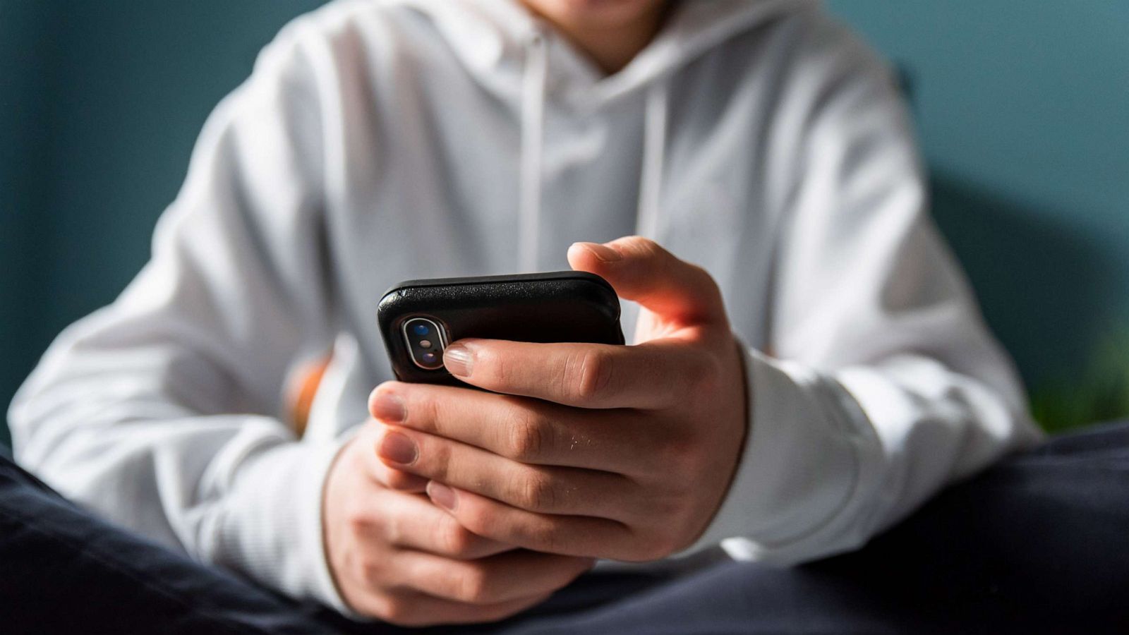 PHOTO: In an undated stock photo, a teen is sitting and lookin at their phone.