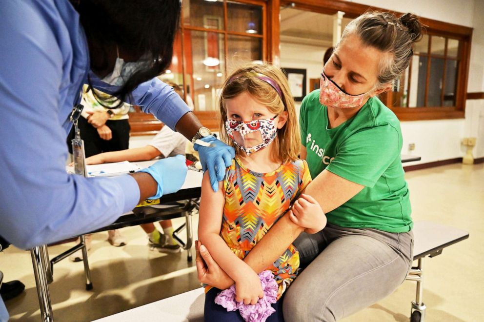 PHOTO: A 5 year old gets her first COVID-19 vaccine shot with her mother in Denver, Nov. 16, 2021. 