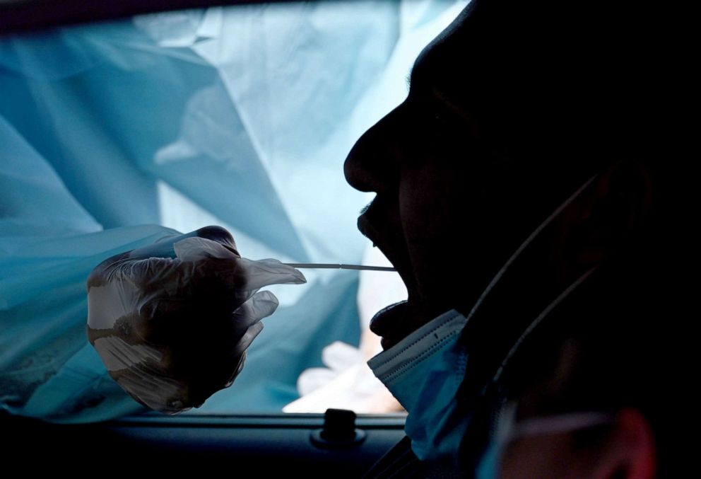 PHOTO: A healthcare worker collects a test sample from a motorist at a drive-through coronavirus testing center in Los Angeles, Sept. 29, 2020.