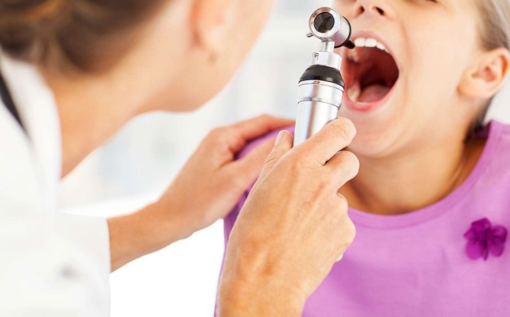 PHOTO: A doctor examines a child's throat with otoscope in an undated stock photo.